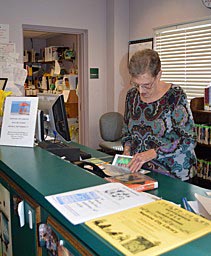Coaster Photo - Neptune City Head Librarian Patty Scott sorts through books at the libary which is celebrating its 90th year.