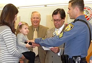 Coaster Photo - Ocean Township police Detective Bryan Morgan (right) was promoted to the rank of Sergeant at the Nov. 10 Township Council meeting.  Mayor Christopher Siciliano administered the oath of office while Morgan’s wife, Andrea, and his two-year-old daughter, Olivia, help hold the Bible. Councilman Richard Long looks on.
