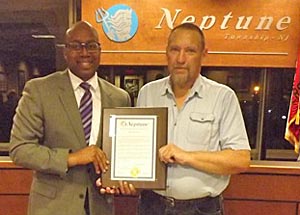 Coaster Photo - Neptune Mayor Kevin McMillan presents a special proclamation to resident Lou Rochelle at this week’s Township Committee meeting.