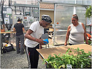 Asbury Park residents Shadajah Ellis and her grandmother Sandra Irizarry learning to start microgreens on food grade burlap in the farm’s paid work experience program.