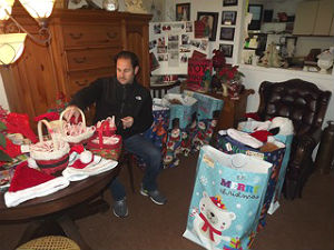Ross Limo owner Martin Ross packs up holiday gifts and goodies in preparation for Santa to delver them this week to needy Neptune families. Coaster photo.